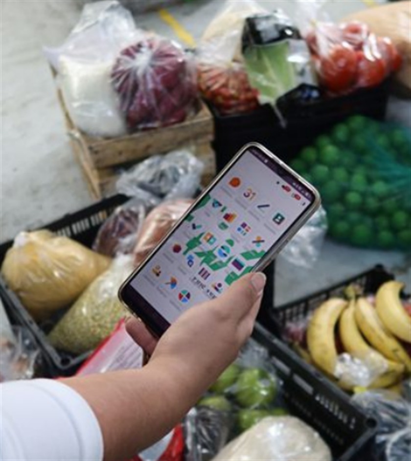 Captura de inventario desde el teléfono, en el piso de una bodega de fruta y verdura